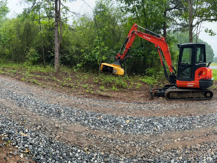 Gravel driveways: a red mini excavator beside a newly graveled drive