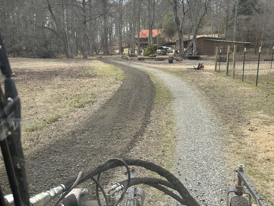 Track loader regrading a rutted gravel drive, gravel driveway repair