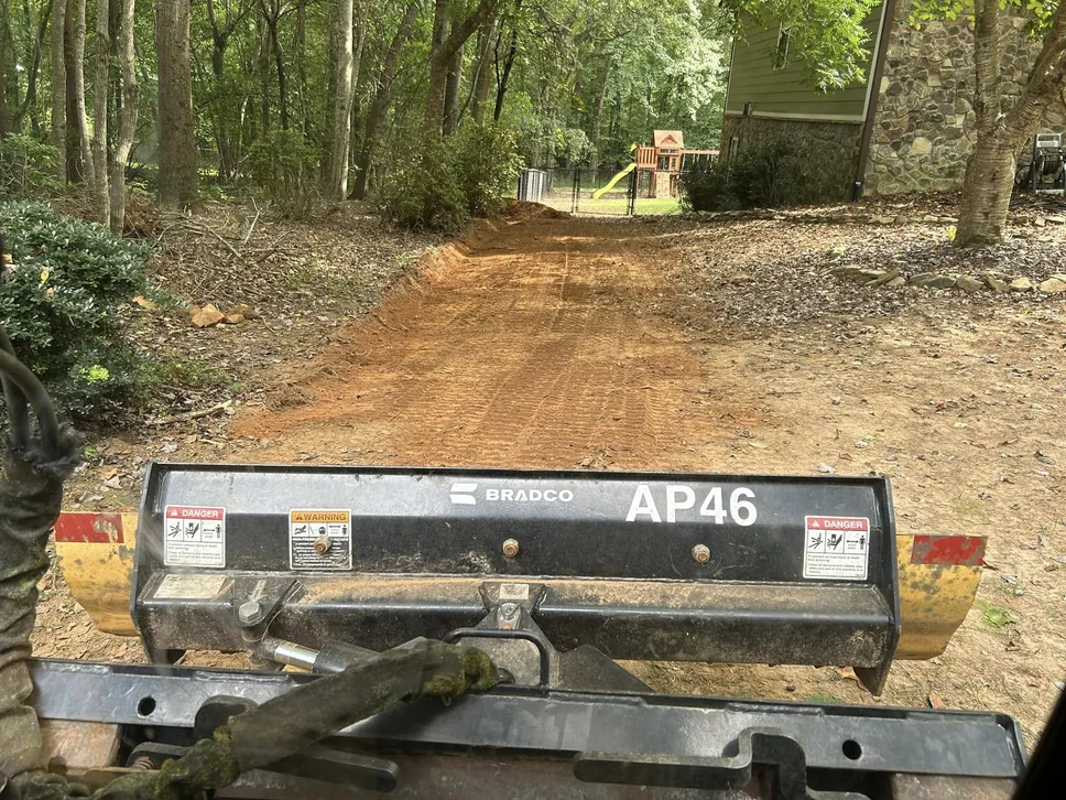 Freshly graded and leveled red clay ground seen from the track loader, land grading
